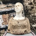 Γυναικεία μαρμάρινη κεφαλή, ένθετη σε άνω ενδεδυμένο κορμό από πωρόλιθο με προέλευση μνημειώδη ελληνιστικό    
τάφο στη ΝΔ πλαγιά της Ακρόπολης της Πλατιάνας. Αρχαιολογικό Μουσείο Πύργου.